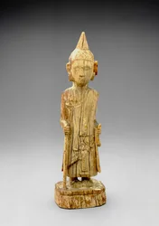 Figur av den ångerfulla Buddha som går och håller i en stav, tidig Mandalay-stil